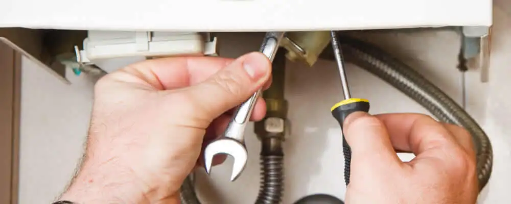 Boiler repair technician tightening pipe fittings and connections in Spokane, WA