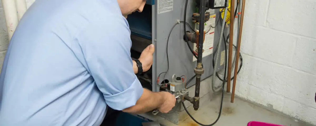 Furnace repair technician inspecting and servicing a home heating system in Spokane, WA