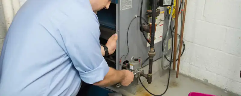 Furnace repair technician inspecting and servicing a home heating system in Spokane, WA