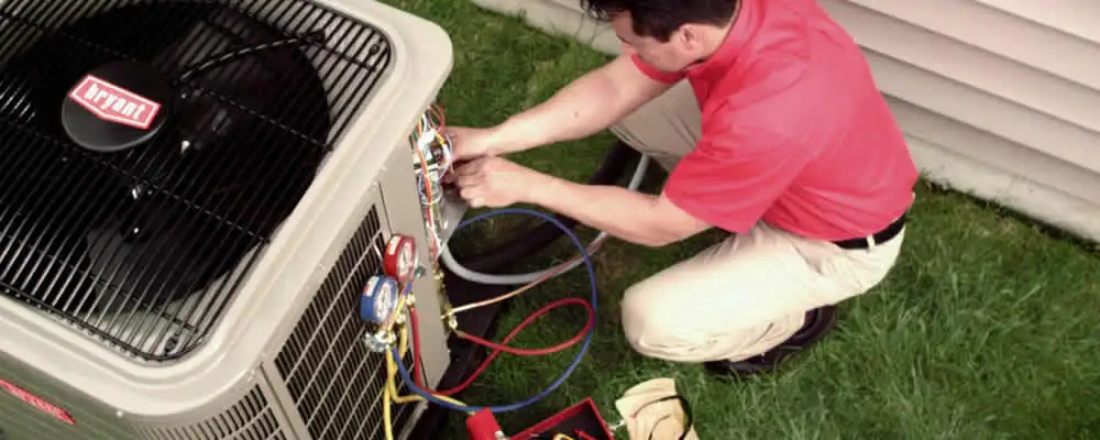 HVAC technician servicing an outdoor air conditioner unit in Spokane, WA